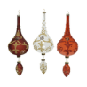 Three ornate, teardrop-shaped ornaments in red and gold, elegantly decorated.