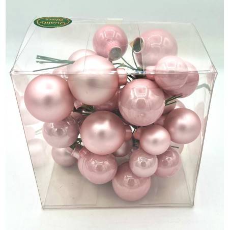 A clear box filled with various pink, glossy, spherical ornaments.