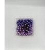 A clear container filled with various shades of purple decorative balls.