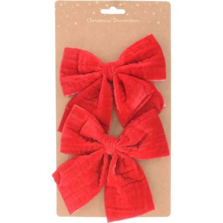 Two large, plush red velvet bows on a brown card with a subtle dot pattern.