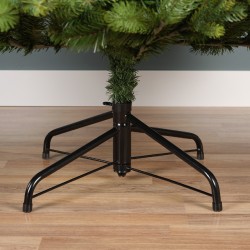 Een metalen standaard ondersteunt een groene kunstkerstboom op een houten vloer.