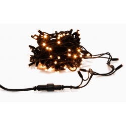 A tangled bundle of warm white fairy lights on dark wire, glowing softly.