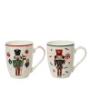 Two festive mugs with nutcracker designs, featuring red and green accents and holiday motifs.