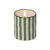 A green and white striped candle with a flickering flame atop a wavy edge.