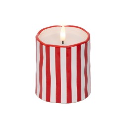 A white candle with red vertical stripes, featuring a flickering flame at the top.