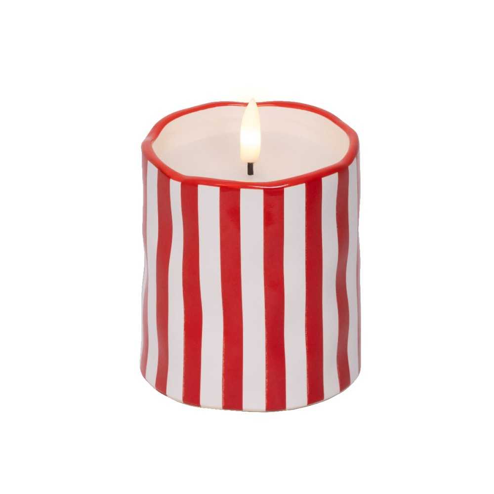 A white candle with red vertical stripes, featuring a flickering flame at the top.
