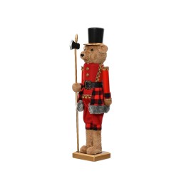 Een teddybeer in een rode uniform met een hoge hoed en een staf, staand op een gouden voet.