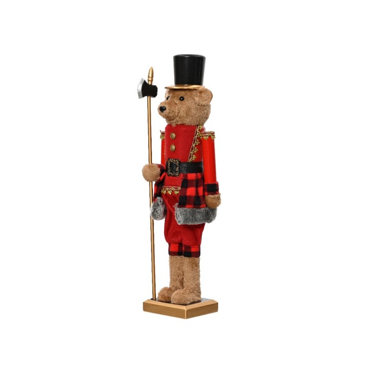 Een teddybeer in een rode uniform met een hoge hoed en een staf, staand op een gouden voet.