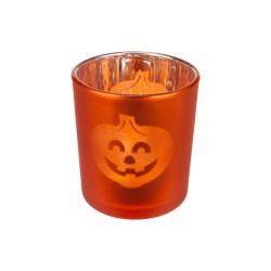An orange glass candle holder with a smiling jack-o'-lantern design.
