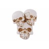 Three stacked skulls in a weathered white finish, showcasing intricate cracks and details.