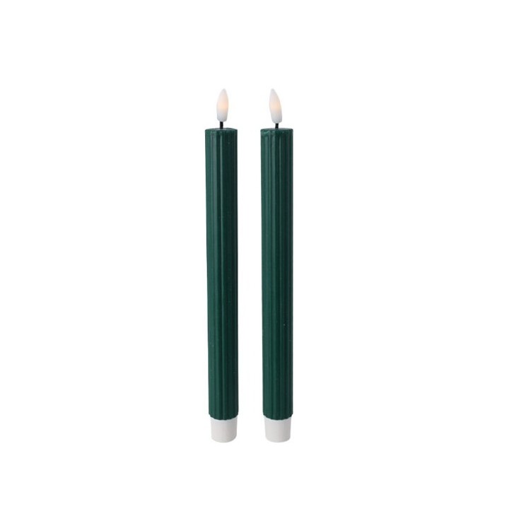 Two tall, dark green candles with white bases and flickering flames on top.