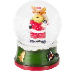 Kerstsneeuwbol met een rendier in een rode outfit op een groene basis met kerstdecoratie.