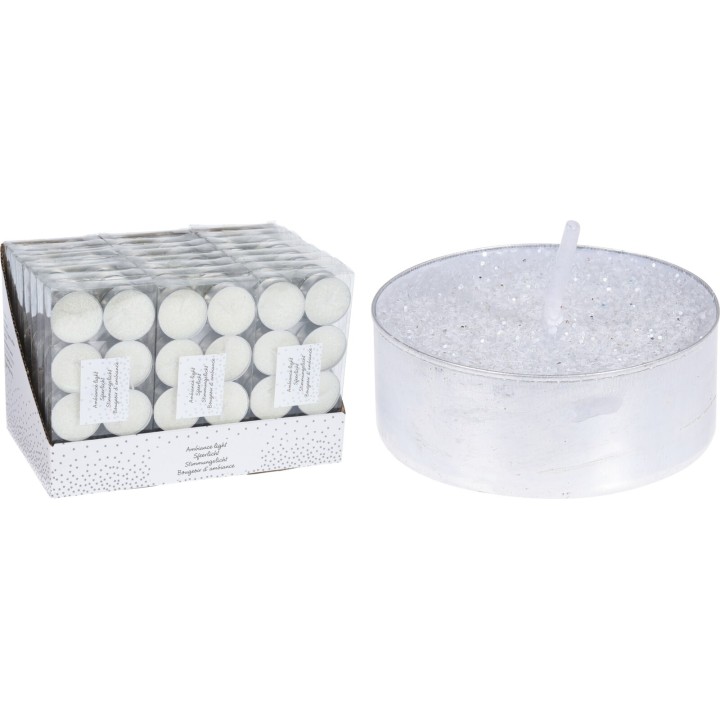 Zeshoekige witte theelichten in een glanzende doos naast een grote, transparante kaars met glitters.