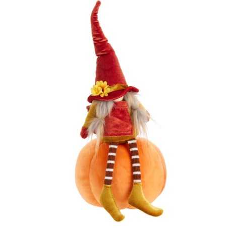 Een schattige pop met een rode hoed zit op een oranje pompoen, met gestreepte sokken.