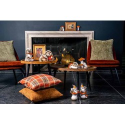 Gezellige woonkamer met fauteuils, houten tafels, kussens en schattige decoraties bij een haard.