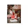 A vintage Santa figurine with a child, surrounded by Christmas decor and a cozy setting.