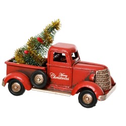Retro rode vrachtwagen met een mini kerstboom en gouden versiering in de laadbak.