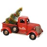 Retro rode vrachtwagen met een mini kerstboom en gouden versiering in de laadbak.
