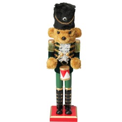 Een teddybeer in militaire uniform, met gouden accenten en een hoge zwarte muts.