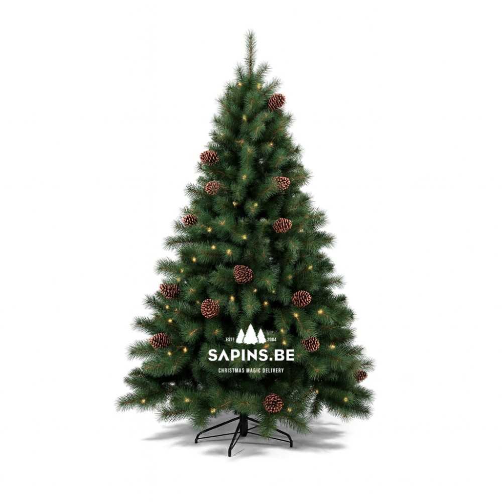 Groene kunstkerstboom met dennenappels en warme lichtjes, op een zwarte standaard.