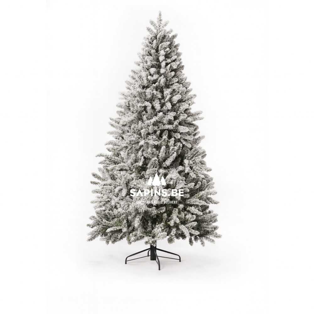 Sneeuwbedekte kunstkerstboom op een zwarte standaard, met volle, groene takken.