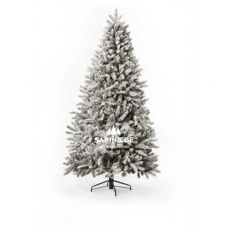 A snowy artificial Christmas tree with lush, frosted branches stands on a simple black base.