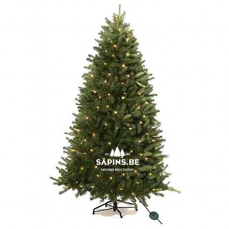A lush green artificial Christmas tree adorned with warm white lights.