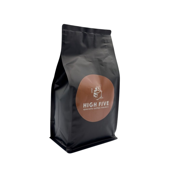Zwarte koffieverpakking met een ronde, bruine sticker en de tekst "HIGH FIVE".