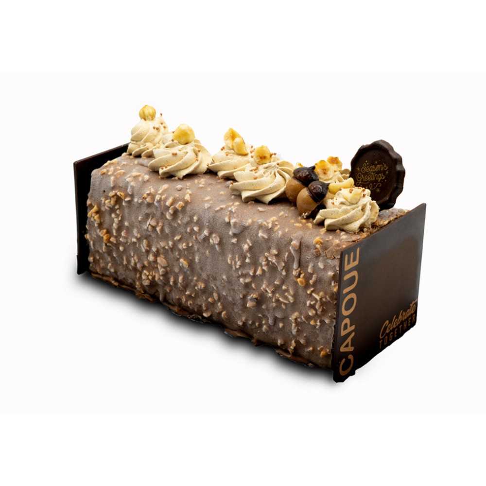 A rectangular cake topped with creamy swirls, nuts, and decorative chocolates.