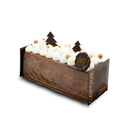 Een chocoladecake met witte room, gouden decoraties en kerstboompjes van chocolade.