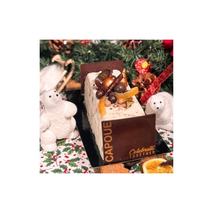 Een feestelijke cake versierd met chocolade, noten en sinaasappelschijfjes, omringd door kerstdec...
