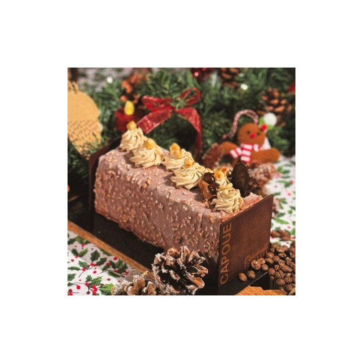 Een feestelijke chocoladetaart, versierd met crème, noten en kerstdecoraties.