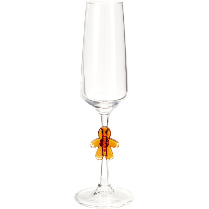 A clear champagne flute with a whimsical gingerbread man charm on the stem.