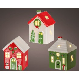 Drie kleurrijke, keramische huisjes in kerstthema met lichtjes en feestelijke versieringen.