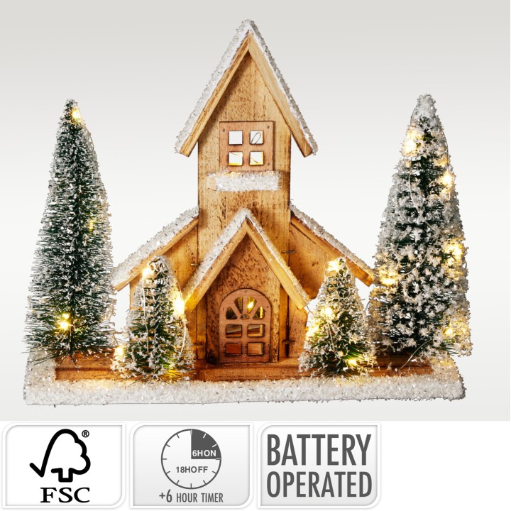 A charming wooden church surrounded by frosted evergreen trees, softly illuminated.