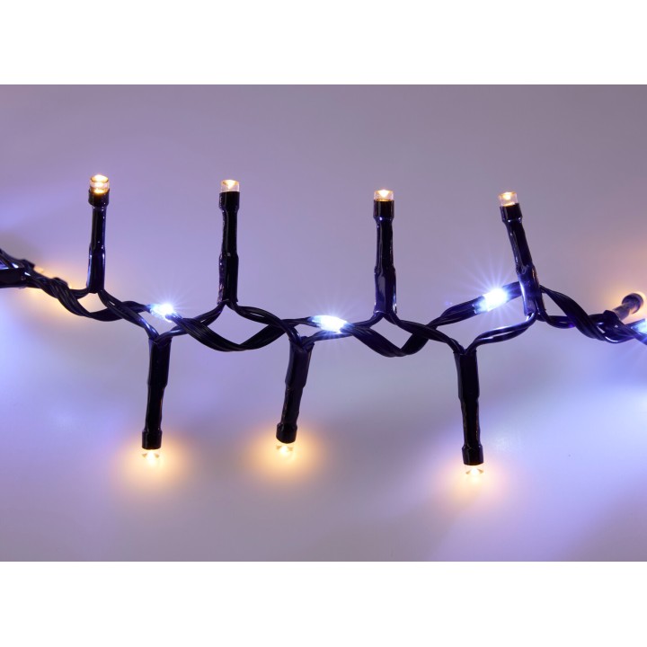 A dark, twisted string of lights with warm and cool glowing bulbs.