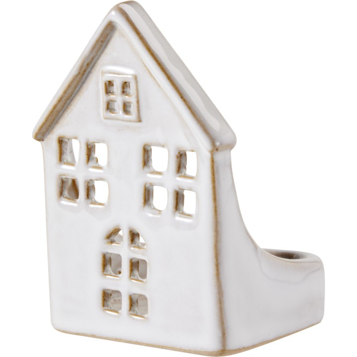 A small, white ceramic house-shaped decorative object with cut-out windows.