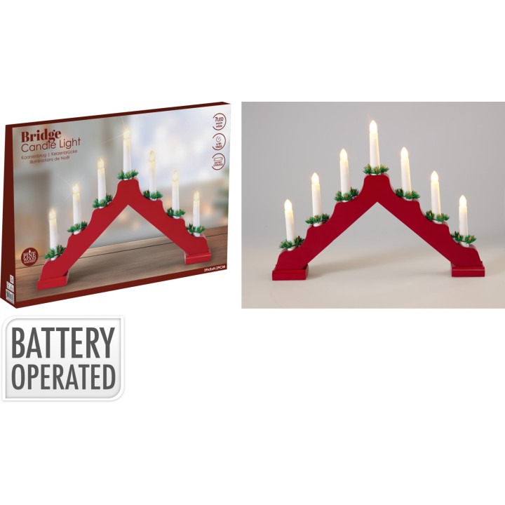 A red bridge-shaped candle holder with six white candles and greenery accents.