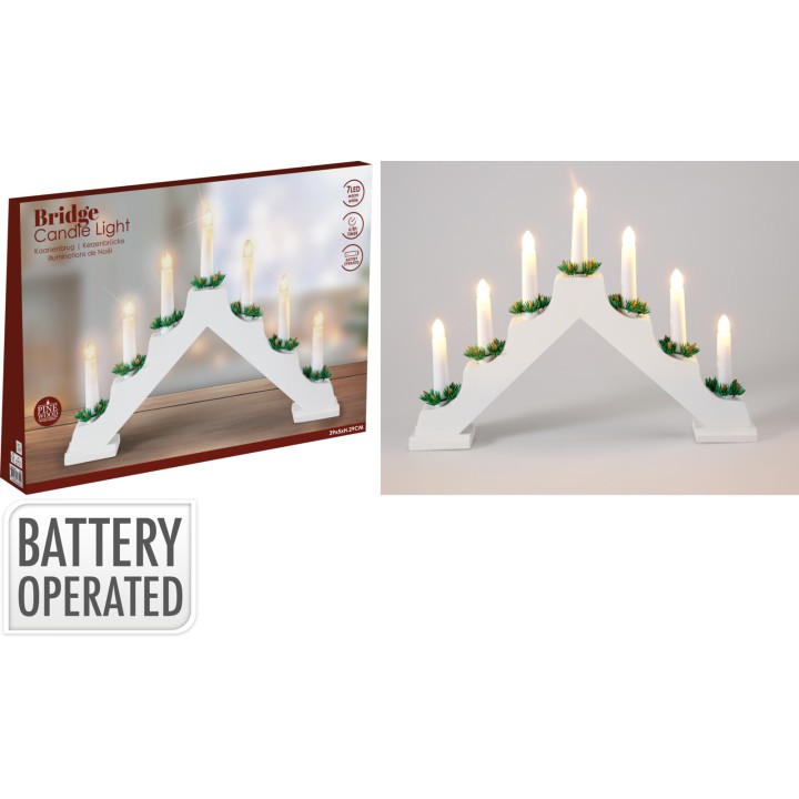 A white bridge-shaped candle holder with green accents and glowing candles.