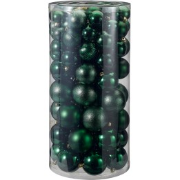A clear cylinder filled with various green Christmas ornaments, shiny and matte textures.