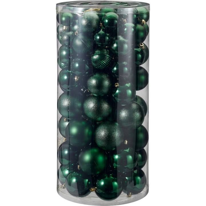 A clear cylinder filled with various green Christmas ornaments, shiny and matte textures.
