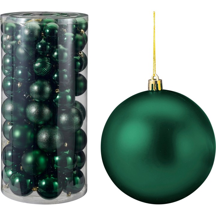 A clear cylinder filled with shiny green Christmas ornaments, featuring one large ornament beside...