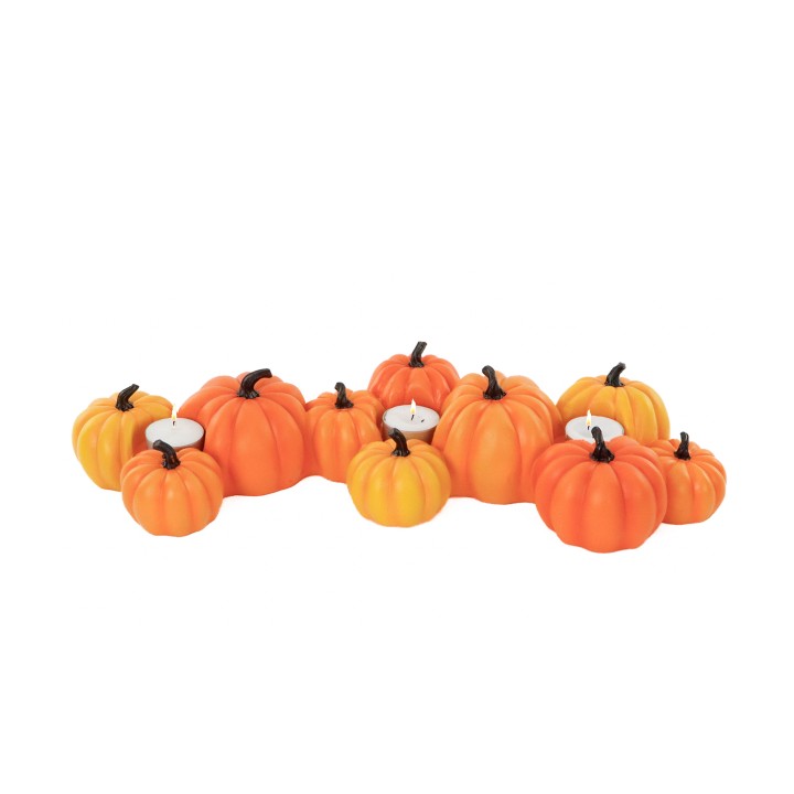 A cluster of vibrant orange pumpkins with small white candles nestled among them.