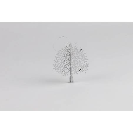 A delicate, white metal tree sculpture with intricate leaf designs and a minimalistic style.