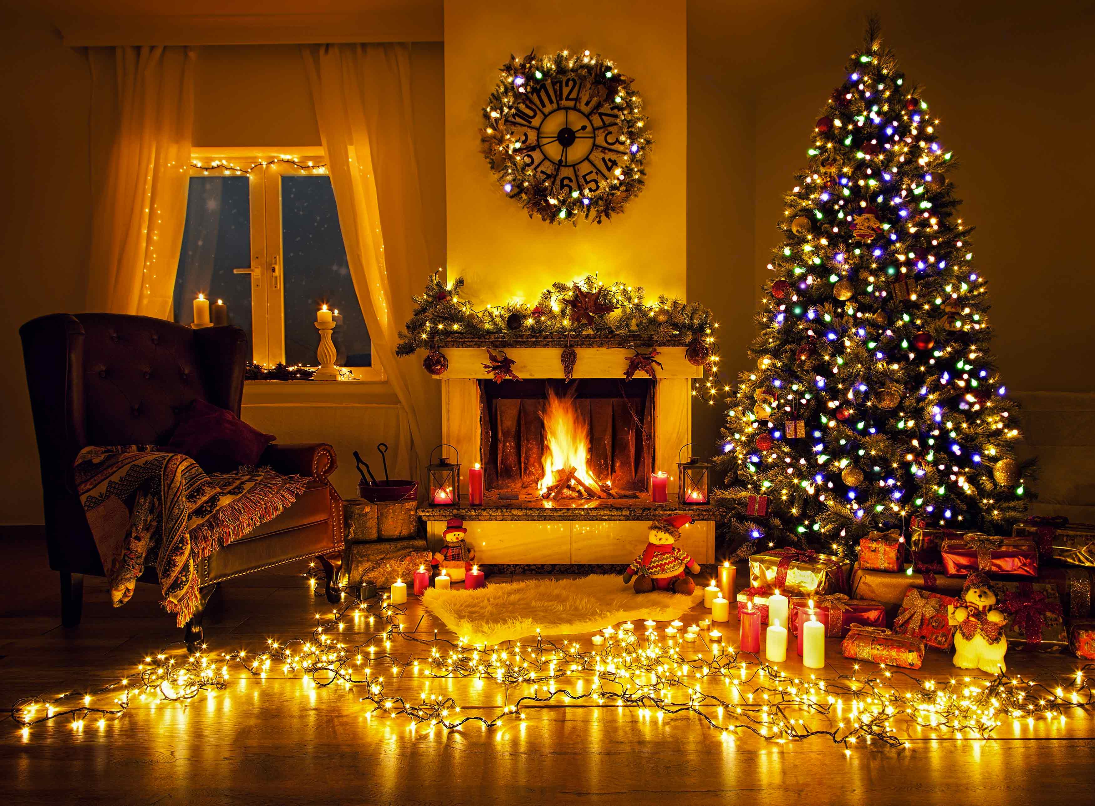 Versierd en verlicht interieur met kerstboom, slingers en open haard
