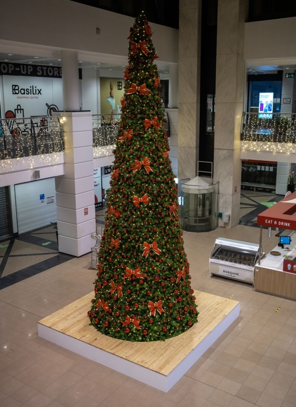 Kerstboom versierd met oranje strikken
